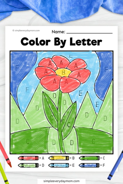 A "Color by Letter" worksheet featuring a red flower with green leaves against a blue sky, with sections labeled by letters corresponding to a color key at the bottom.