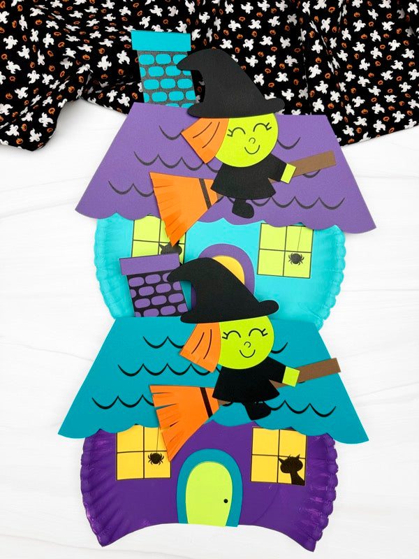 Witch house paper plate craft with witch figures on a white background with ghost fabric on top