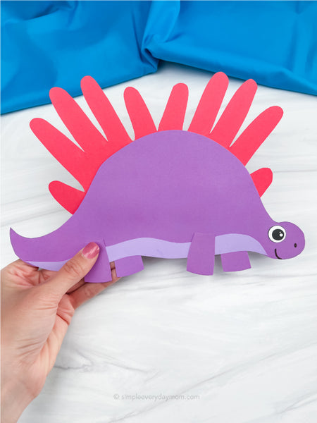 hand holding handprint stegosaurs craft