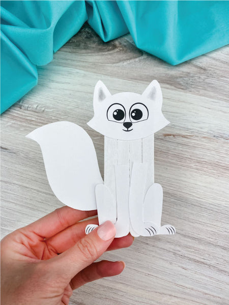 hand holding arctic fox popsicle stick craft