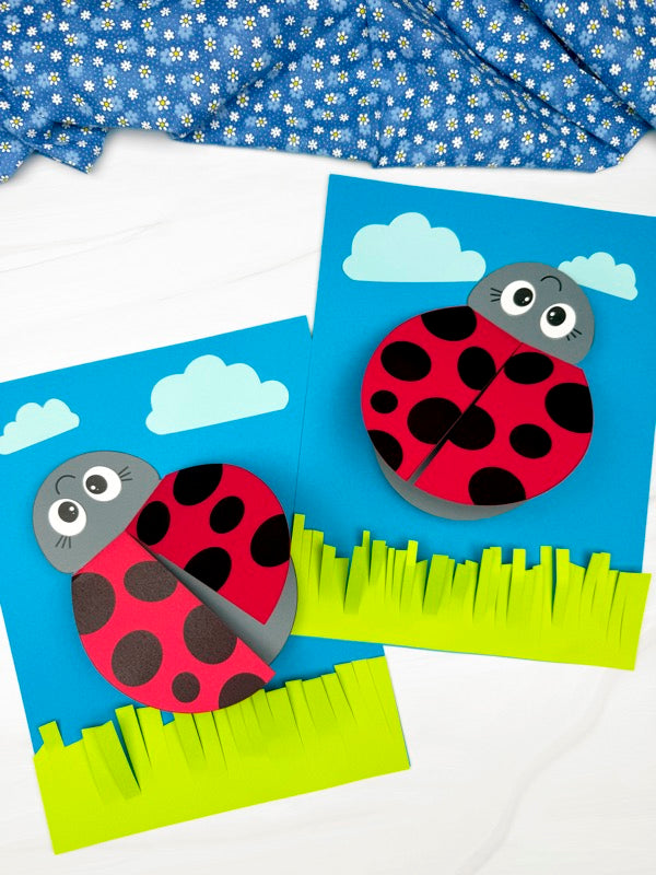 Two paper ladybug crafts on blue backgrounds with clouds and grass.