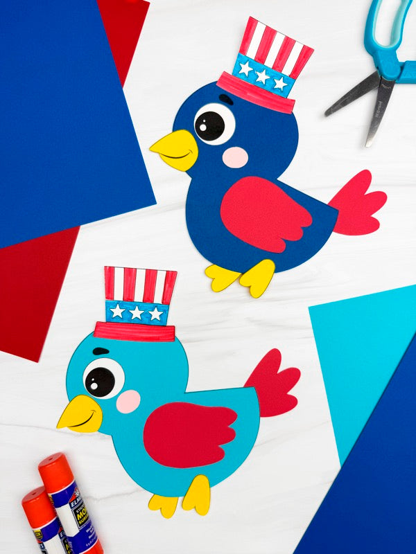 Two patriotic bird crafts for kids on colorful background with scissors and glue