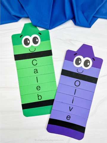 Two colorful name crafts with cartoon faces on a white background