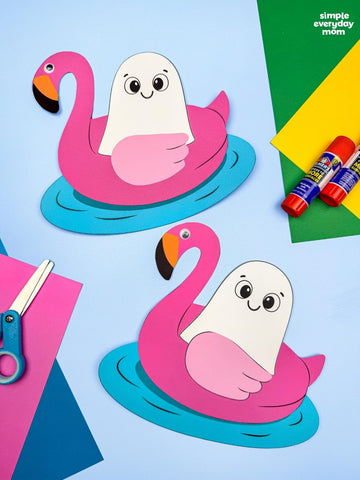 Two Halloween ghosts on flamingo pool float crafts on colored background, with paper, scissors & glue