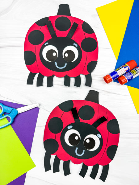 Two handmade paper ladybug pumpkin crafts displayed on a white background with craft supplies including scissors, glue sticks, and colored paper.