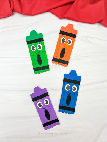 Colorful popsicle stick crayon crafts with big eyes on a white background