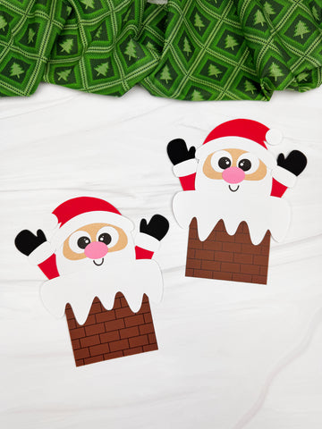 Two Santa in chimney crafts on white background with green fabric 