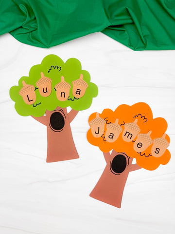 Two paper trees with acorn-shaped letters on a white background