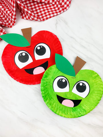 Two paper plate apples with facial features on a white background