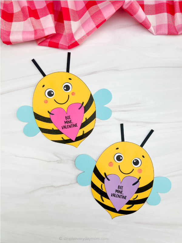 Two bee-shaped Valentine's Day crafts with hearts on a white background.