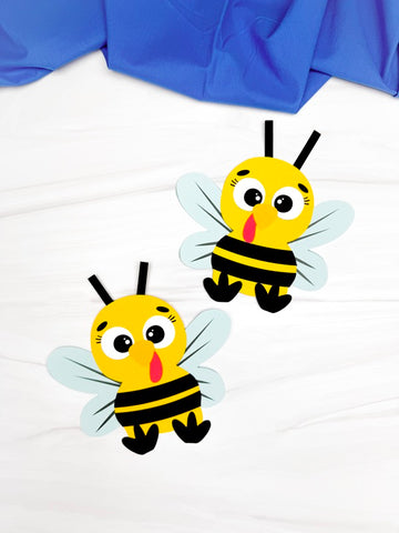 Two bee turkey disguise crafts on a white background with blue fabric partially visible.