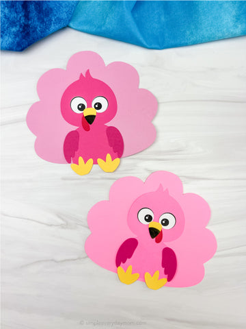 Two flamingo turkey disgiuse crafts with yellow feet on a white background
