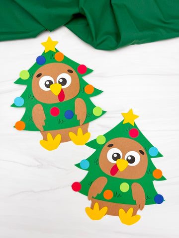 Two turkeys disguised as a Chrsitmas tree on white background with green fabric on top. 