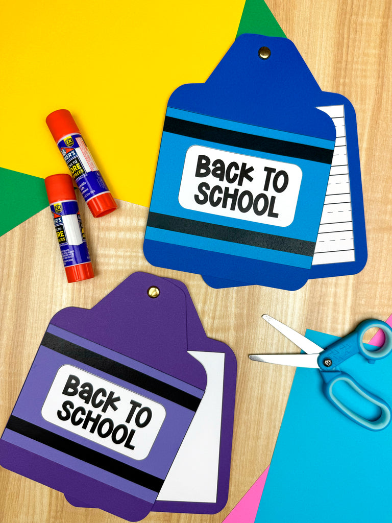 Two 'Back to School' themed crayon books with  glue sticks, and scissors on a colorful background.