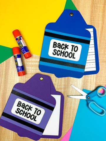 Two 'Back to School' themed crayon books with  glue sticks, and scissors on a colorful background.