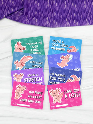 Set of Valentine's Day cards with cartoon axolotls on a white surface.