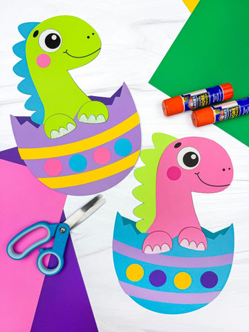 Colorful dinosaur craft project with glue sticks and scissors on a white background