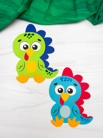 Two colorful turkeys disguised as a dinosaur on a white background with green fabric partially visible.