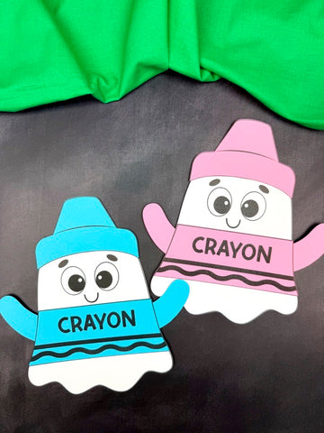 Two disguise a ghost as crayons crafts on black surface.