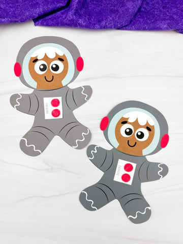 Two gingerbread men in astronaut suits on a white background