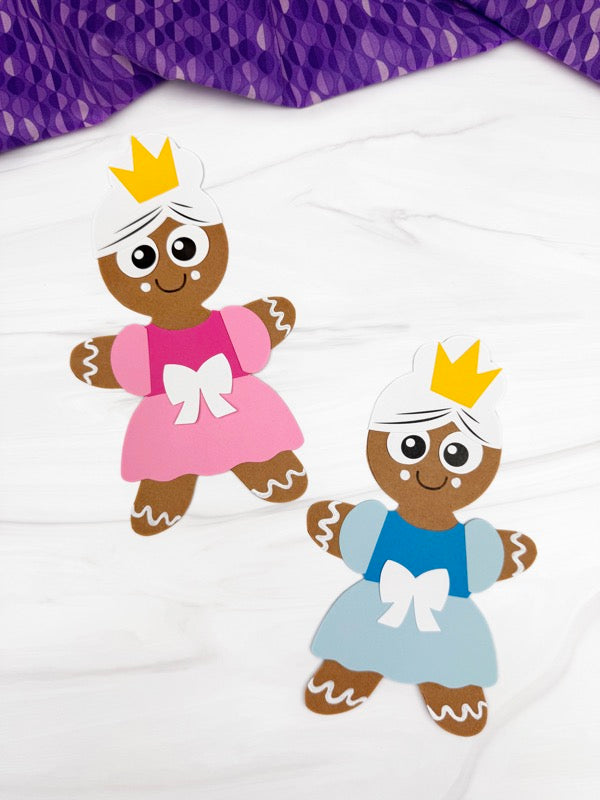 Two gingerbread princess crafts, one in pink dress the other in blue dress, on a white background.