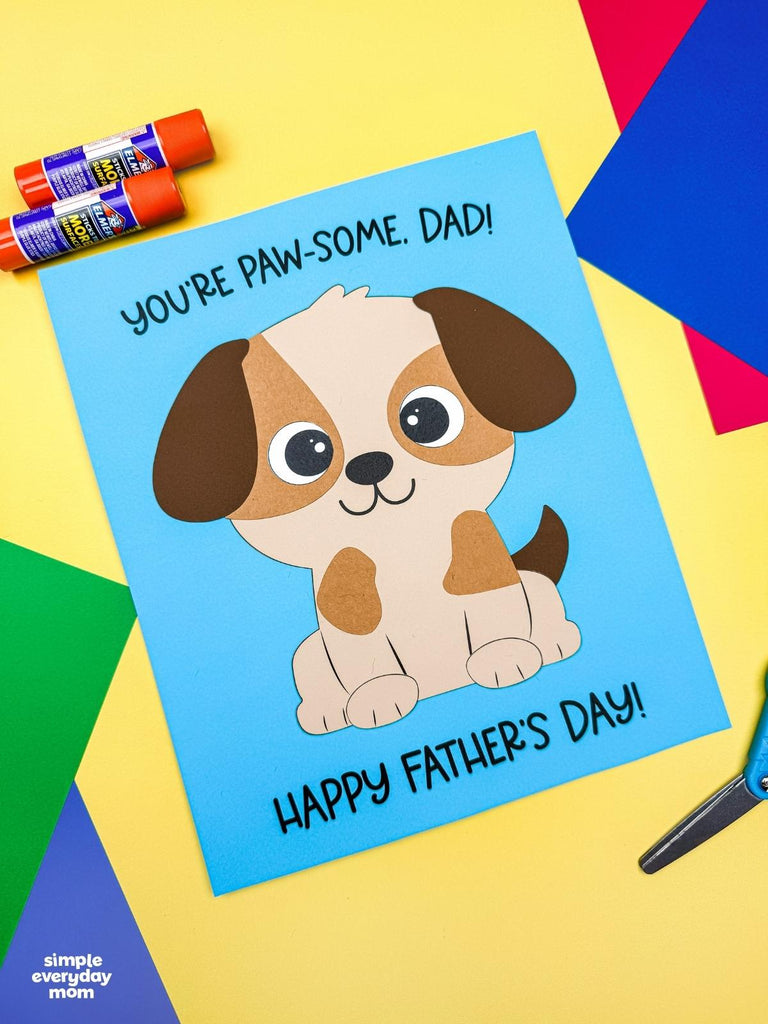Father's Day dog craft for kids on colorful background with glue sticks and scissors
