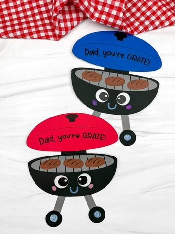 Two Father's Day grill crafts on white background with red and white checkered fabric on top