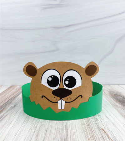 Children's paper hat with a groundhog design on a wooden surface