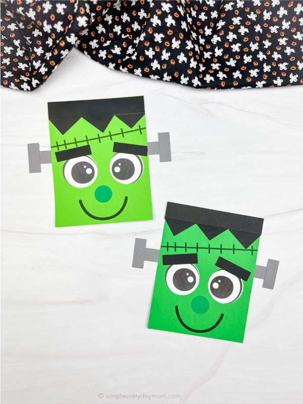 Two Frankenstein-shaped crafts on a white background with black ghost fabric on top 