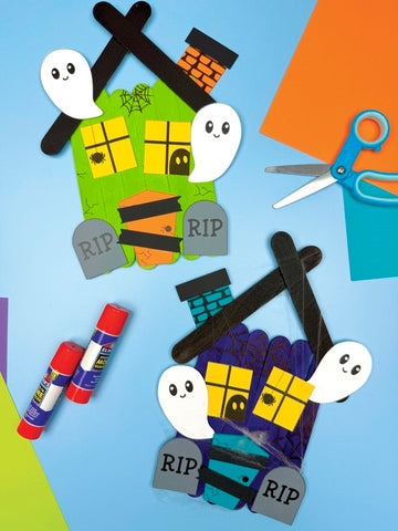 Halloween-themed haunted house project with paper ghosts, tombstones, on a colorful background.