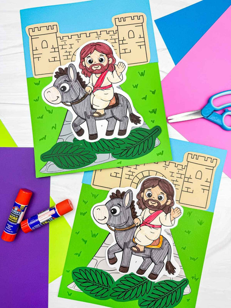 Colorful paper craft activity with Jesus and donkey on a green background, surrounded by craft supplies.