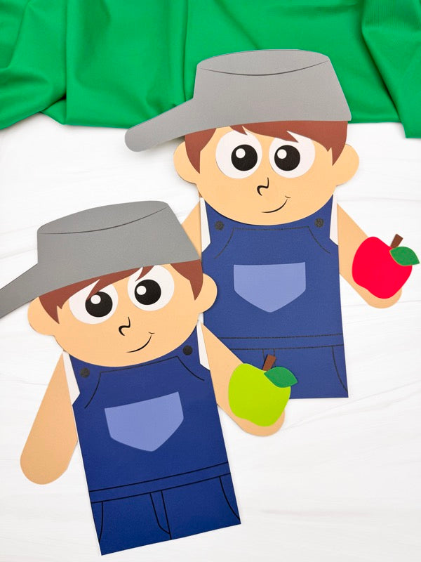 Two Johnny Appleseed puppet crafts wearing blue overalls and pot hats, holding green and red apples.