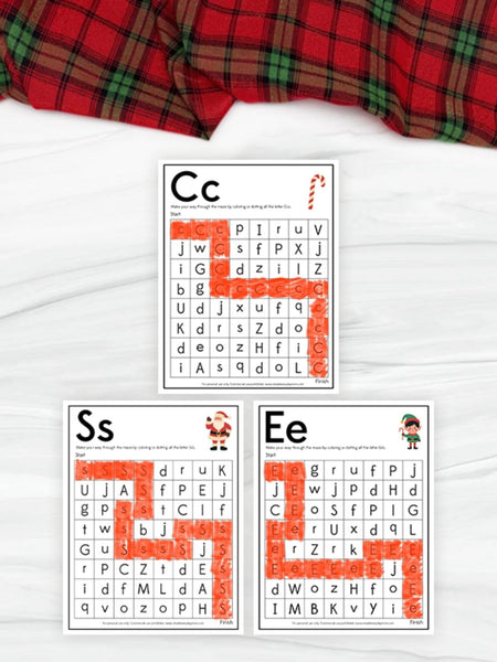 Educational letter maze worksheets with letters C, S, and E on a white surface with plaid fabric.