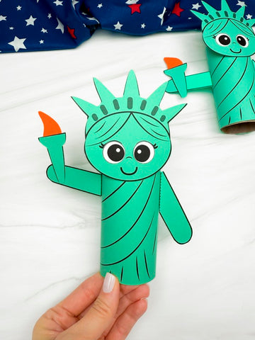 hand holding Statue of Liberty cardboard tube craft with a 2nd one in the background