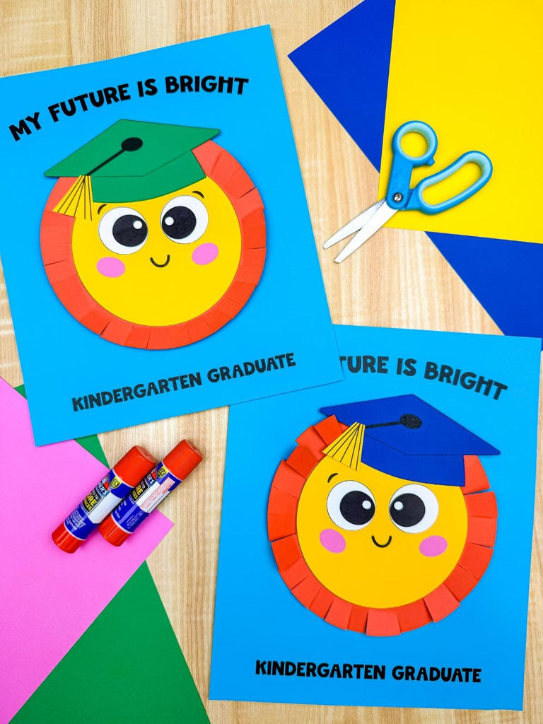 Two sun graduation crafts labeled 'My Future is Bright Kindergarten Graduate' with scissors and glue sticks on a wooden surface.