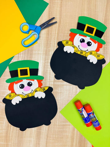 leprechaun in a pot of gold crafts on wood background with crafts supplies
