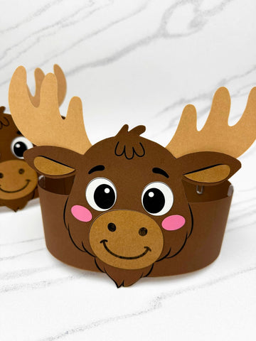 Two paper moose hats on a white surface