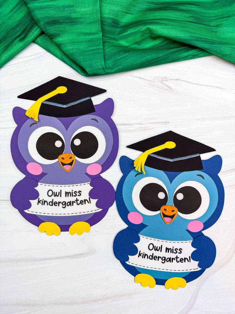 Two cartoon owls crafts wearing graduation caps on a white background with green fabric.