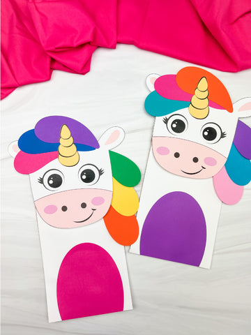 Two rainbow unicorn puppet crafts on white background with pink fabric