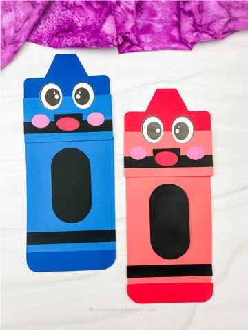 Two paper bag crayon puppets, one blue and one red, with big eyes on a white background.