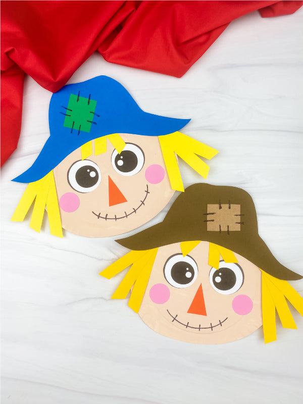 Two paper plate scarecrows on white background with red fabric on the top