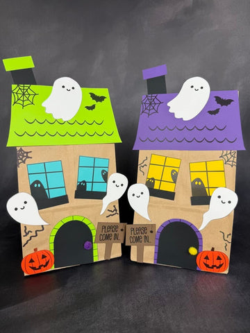 Two Halloween-themed paper bag houses with ghosts on a dark background