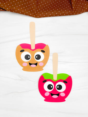Two candy apples crafts with faces on a white background