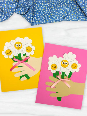 Two handprint Mother's Day crafts on white background with blue fabric on top