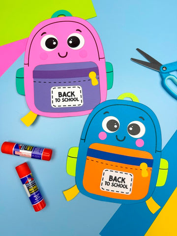 Two colorful backpack crafts with cartoon faces, 'Back to School' labels, and a pair of scissors on a blue background.