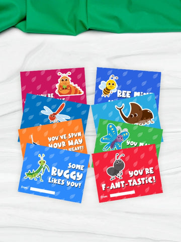 colorful kids' bug Valentine's Day cards on white background with green fabric
