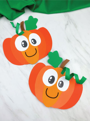 Two paper pumpkins with faces on a white background