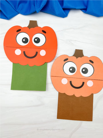 Two paper pumpkin pupet crafts with faces on a white background