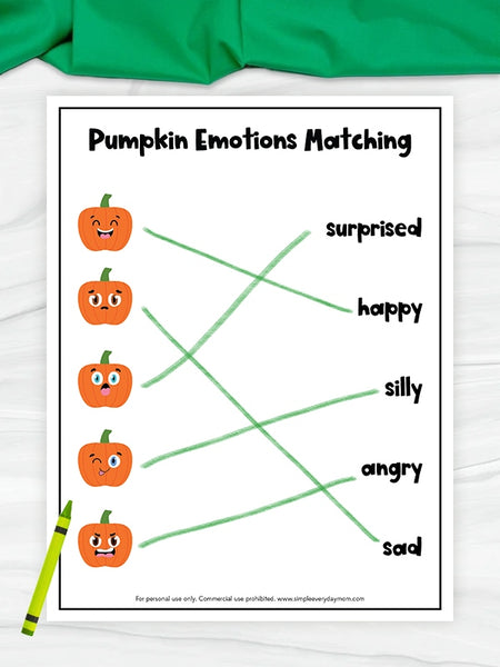 pumpkin emotions matching worksheet on white marble with green fabric on top
