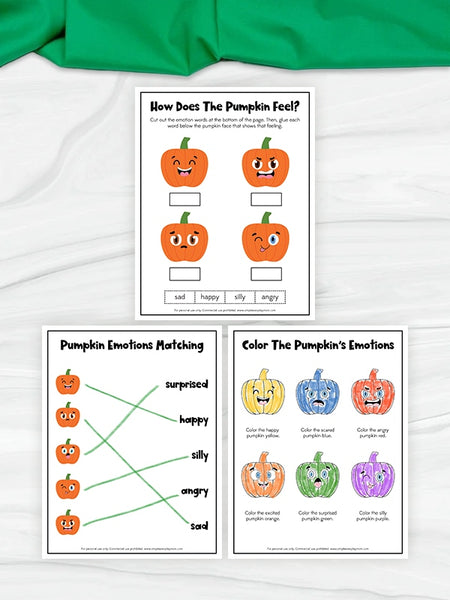 Three printable pumpkin-themed worksheets are arranged on a white fabric background with a green cloth at the top. The worksheets include pumpkin face illustrations, emotion matching, and coloring activities.